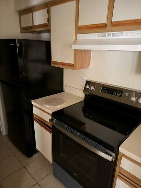 A kitchen features a black refrigerator, a stainless steel electric stove, and light-colored cabinetry — 208 AFTON SQUARE UNIT 208, ALTAMONTE SPRINGS, FL