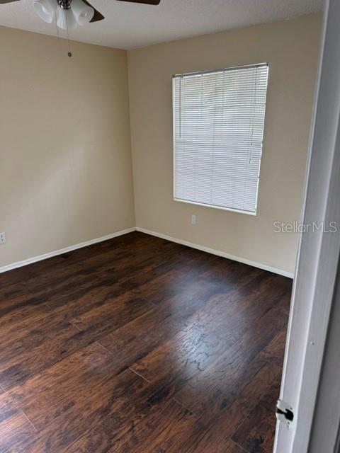 An empty bedroom features dark wood-look flooring, beige walls, and a window with blinds — 208 AFTON SQUARE UNIT 208, ALTAMONTE SPRINGS, FL