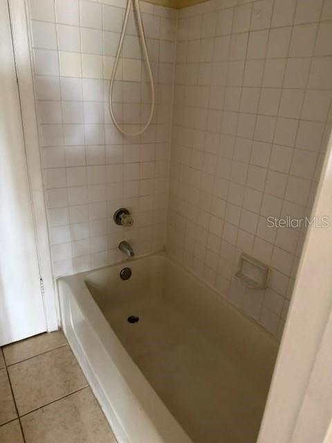 A white bathtub with a shower head and tiled walls in a bathroom — 208 AFTON SQUARE UNIT 208, ALTAMONTE SPRINGS, FL
