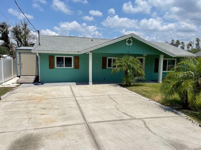 A teal, single-story house with a gray shingled roof and a concrete driveway — 10922 PARK DRIVE, RIVERVIEW, FL