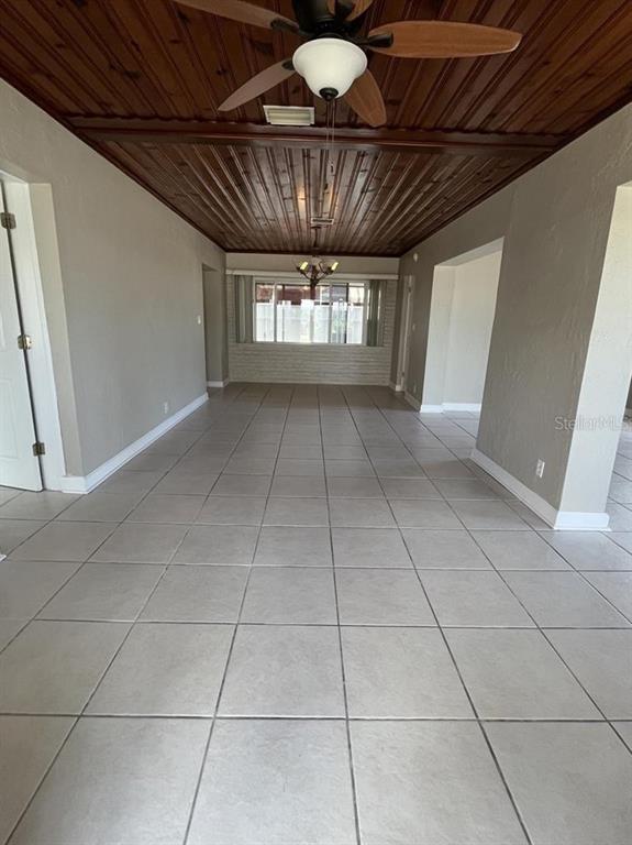 A long room features light-colored tile flooring and a dark wood-paneled ceiling with fans — 360 72ND AVENUE, ST PETERSBURG, FL