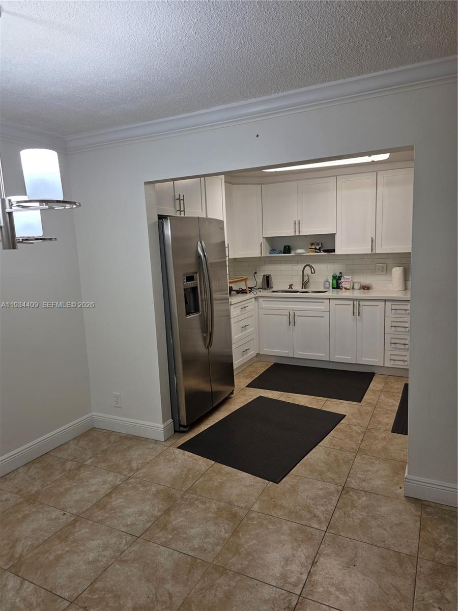 A kitchen with white cabinets, stainless steel appliances, and tiled flooring is visible — 1811 Jefferson St # 501, Hollywood FL 33020, HOLLYWOOD, FL