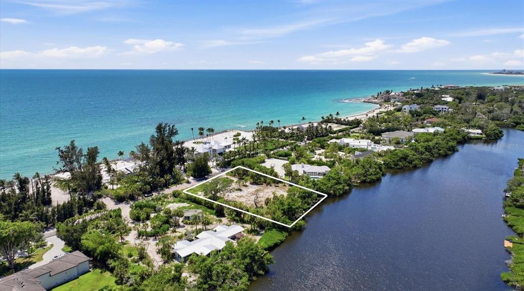 An aerial view shows a vacant waterfront lot outlined in white near the ocean — 7723 SANDERLING ROAD, SARASOTA, FL