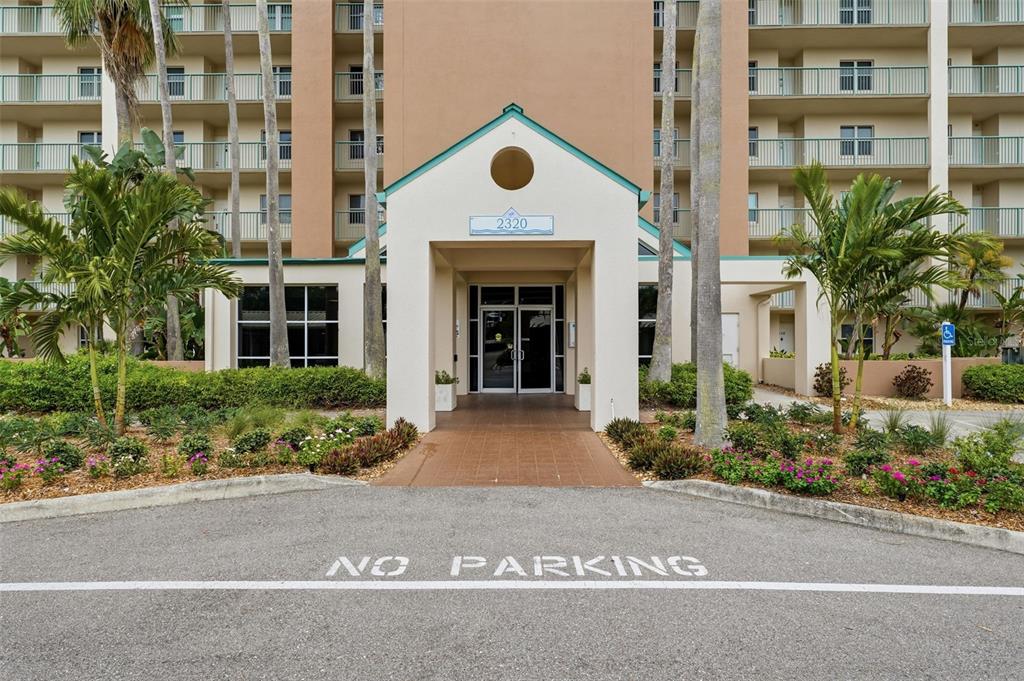 The exterior of a multi-story apartment building features a covered entrance with a glass door — 2320 TERRA CEIA BAY BOULEVARD UNIT 207, PALMETTO, FL
