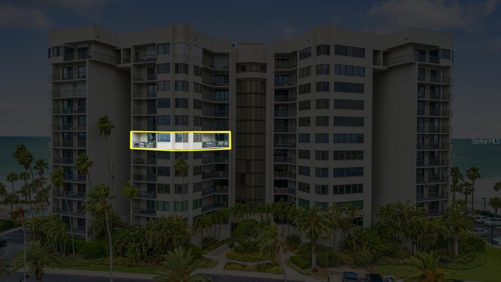 An exterior view of a multi-story beachfront condominium building with a highlighted balcony unit — 1600 GULF BOULEVARD UNIT 717, CLEARWATER BEACH, FL