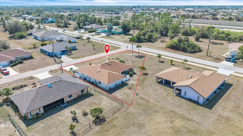 An aerial view shows a single-story house outlined in red within a suburban neighborhood — 1726 BLUE LAKE CIRCLE, PUNTA GORDA, FL