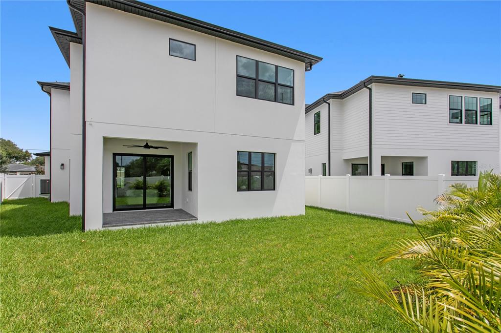 A modern living room features a linear fireplace, tray ceiling, and neutral furniture on hardwood floors — 3613 W NORTH A STREET, TAMPA, FL