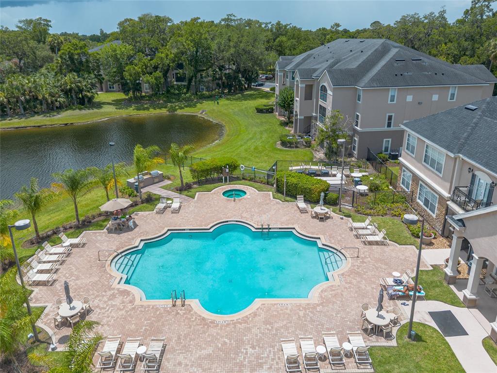 An aerial view shows a swimming pool and hot tub surrounded by lounge chairs — 940 VILLAGE TRAIL UNIT 2-208, PORT ORANGE, FL