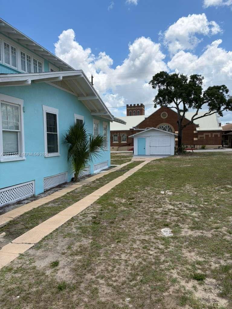 A light blue house exterior features a side walkway leading to a small detached garage — 1870 Lakeview Rd # 1, Sebring FL 33870, SEBRING, FL