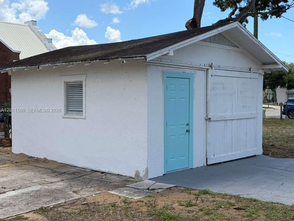 A small, white detached garage features a light blue door and a sliding barn-style door — 1870 Lakeview Rd # 1, Sebring FL 33870, SEBRING, FL