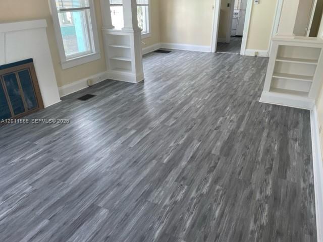 A living room features gray wood-look flooring, a fireplace, and built-in shelving units — 1870 Lakeview Rd # 1, Sebring FL 33870, SEBRING, FL