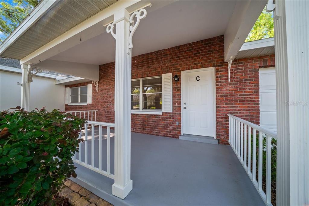 A covered brick porch features a white front door labeled C and white railings — 8874 SW 95TH STREET UNIT C, OCALA, FL