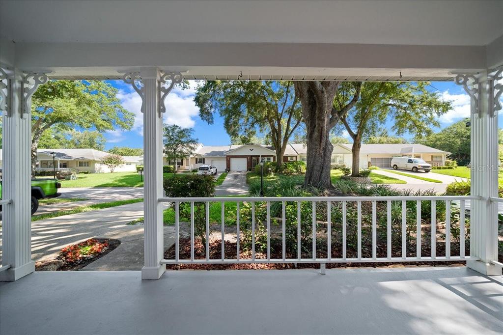 A view from a covered front porch looking out toward a suburban street and houses — 8874 SW 95TH STREET UNIT C, OCALA, FL