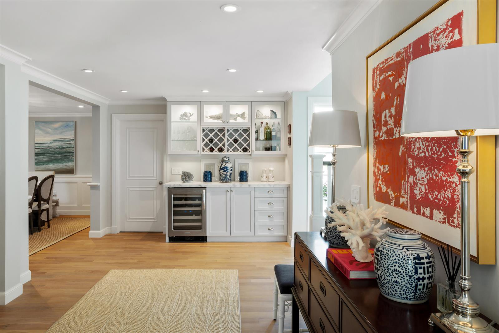 A home bar area features white cabinetry, a wine refrigerator, and a nearby wooden console — 327 Arabian Road, Palm Beach FL 33480, PALM BEACH, FL