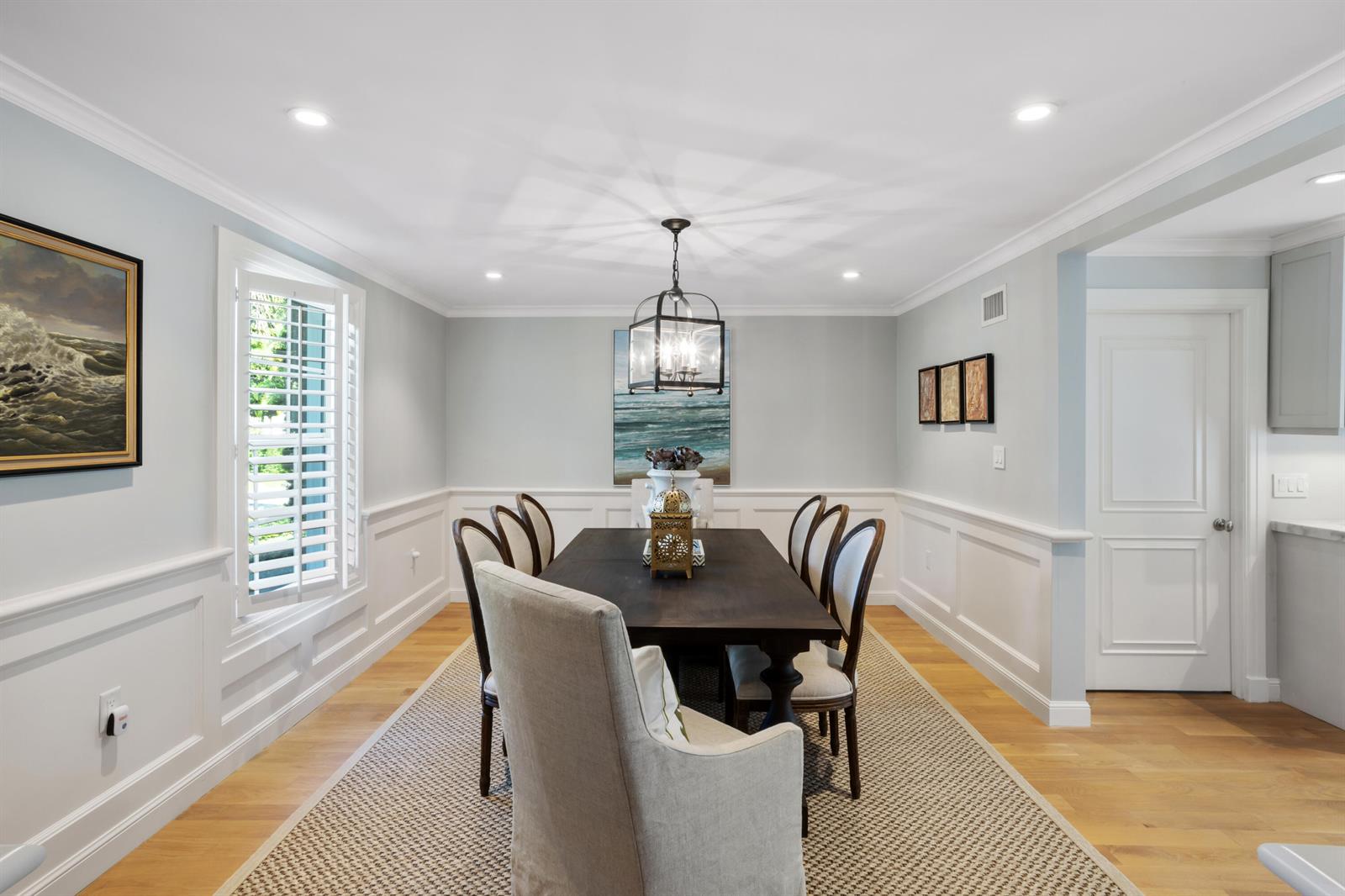 A dining room features a dark wood table, upholstered chairs, wainscoting, and a lantern chandelier — 327 Arabian Road, Palm Beach FL 33480, PALM BEACH, FL