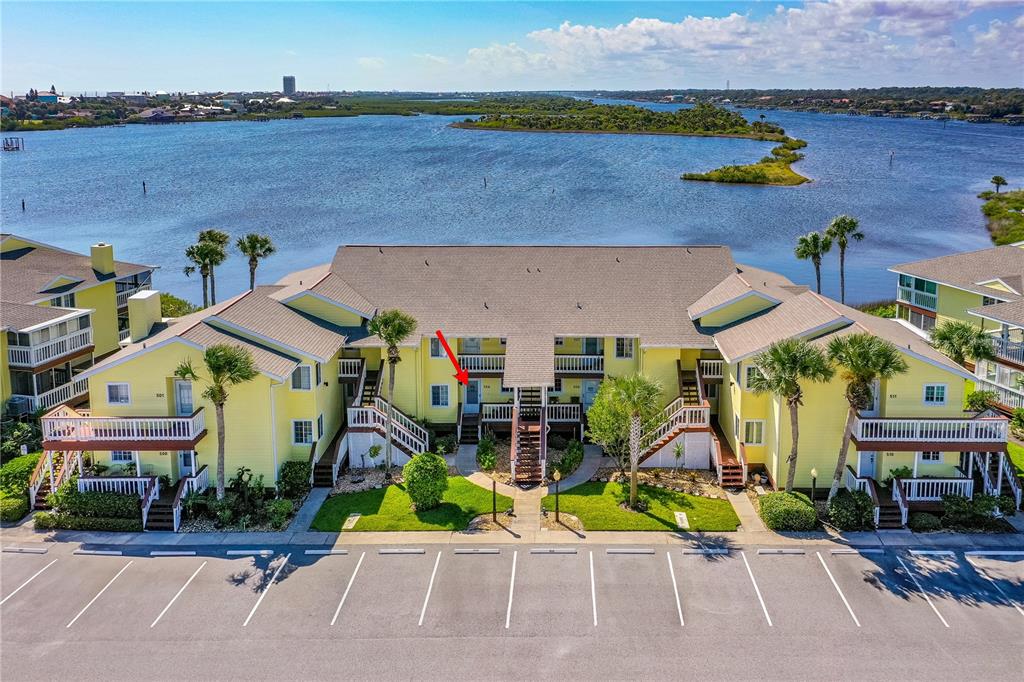 An aerial view of a yellow multi-unit residential building with a red arrow pointing to a door — 504 OCEAN MARINA DRIVE UNIT 504, FLAGLER BEACH, FL