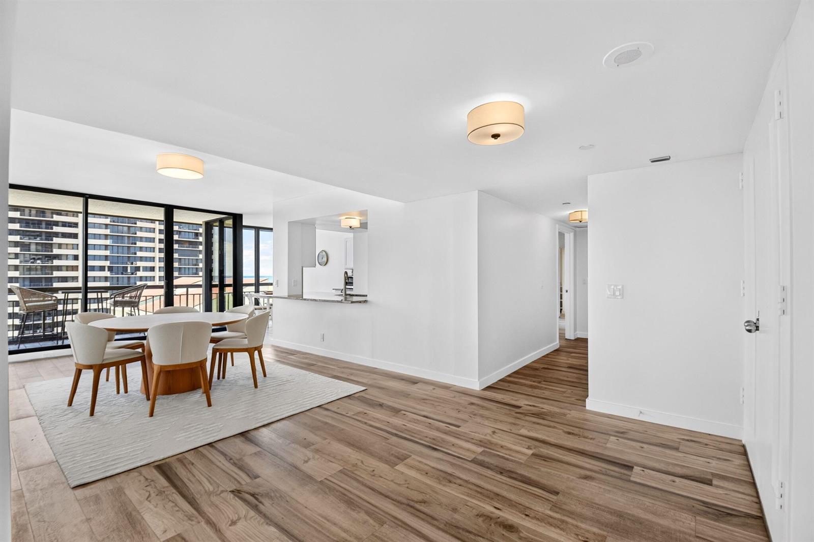 A dining area with a round table and chairs sits beside a kitchen pass-through window — 4000 N Ocean Drive # 703, Singer Island FL 33404, SINGER ISLAND, FL