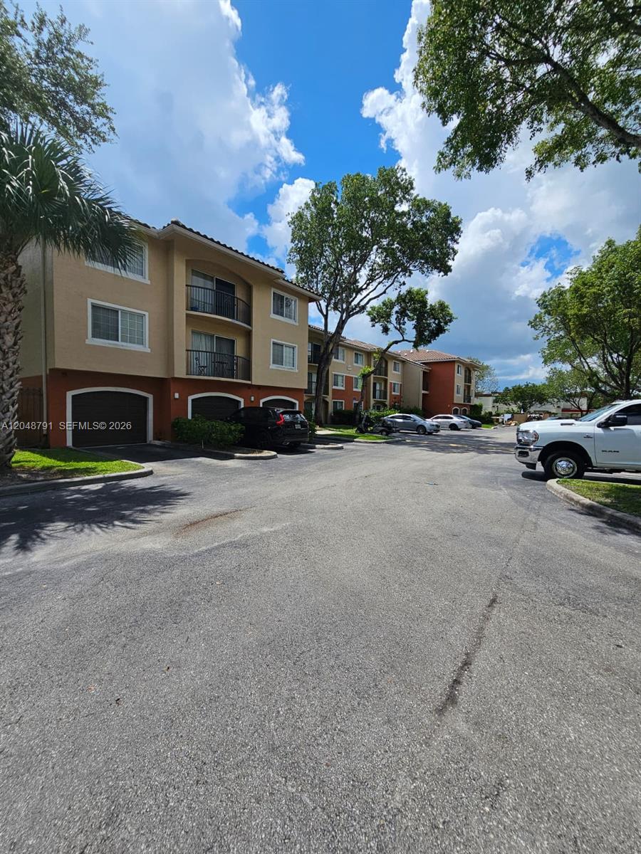 A multi-story apartment building with attached garages and a parking lot in front — WEST PALM BEACH, FL