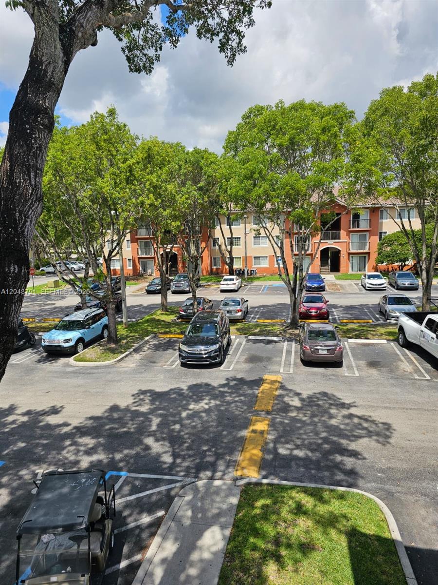 An exterior view of a multi-story apartment building with a parking lot in front — WEST PALM BEACH, FL