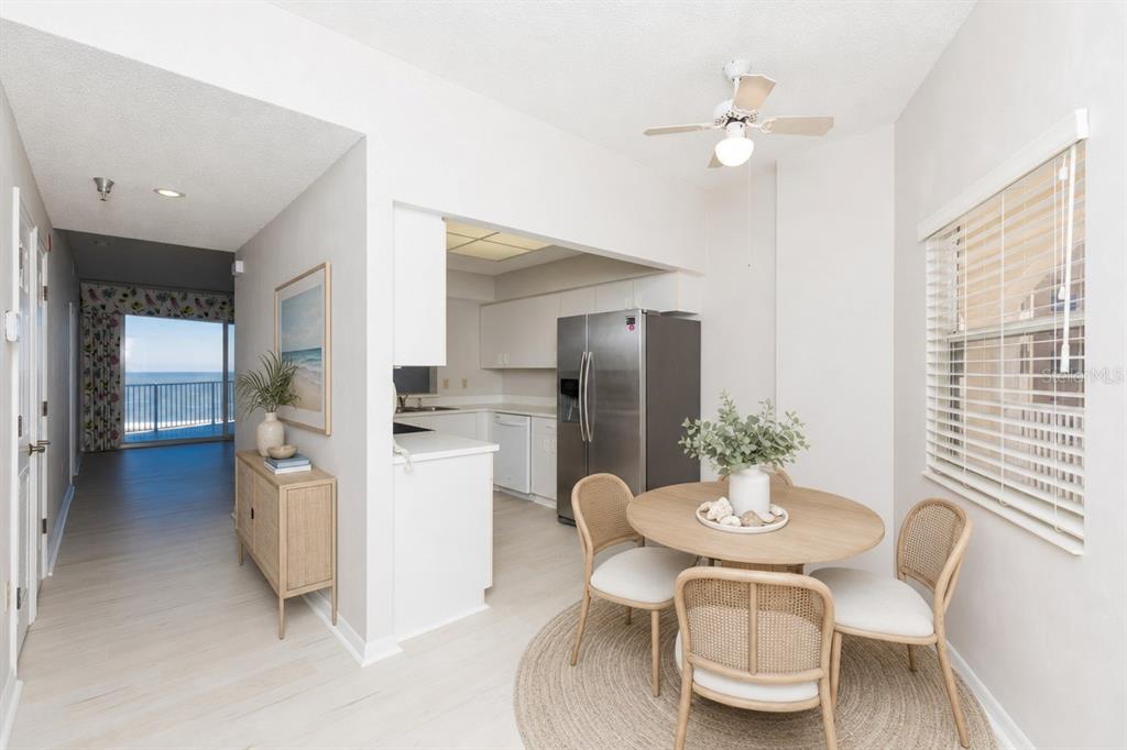 A dining area with a round table and chairs sits adjacent to a kitchen — 104 SURFVIEW DRIVE UNIT 1406, PALM COAST, FL