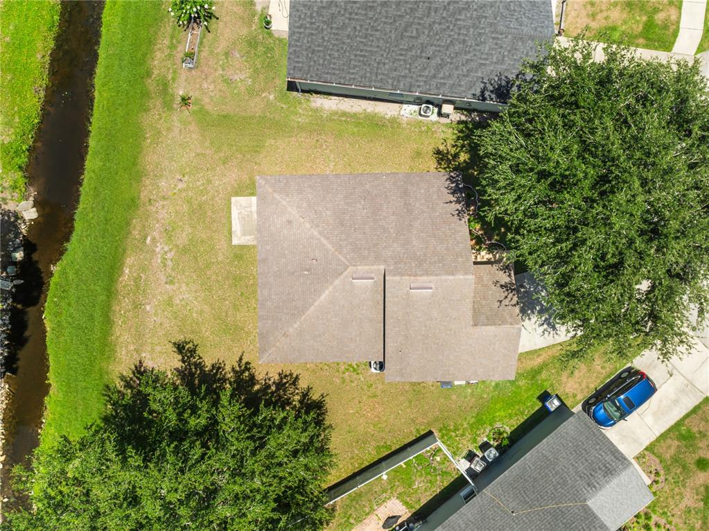 An aerial view shows a house with a brown roof, a large tree, and lawn — 2944 COOL BREEZE CIRCLE, ST CLOUD, FL