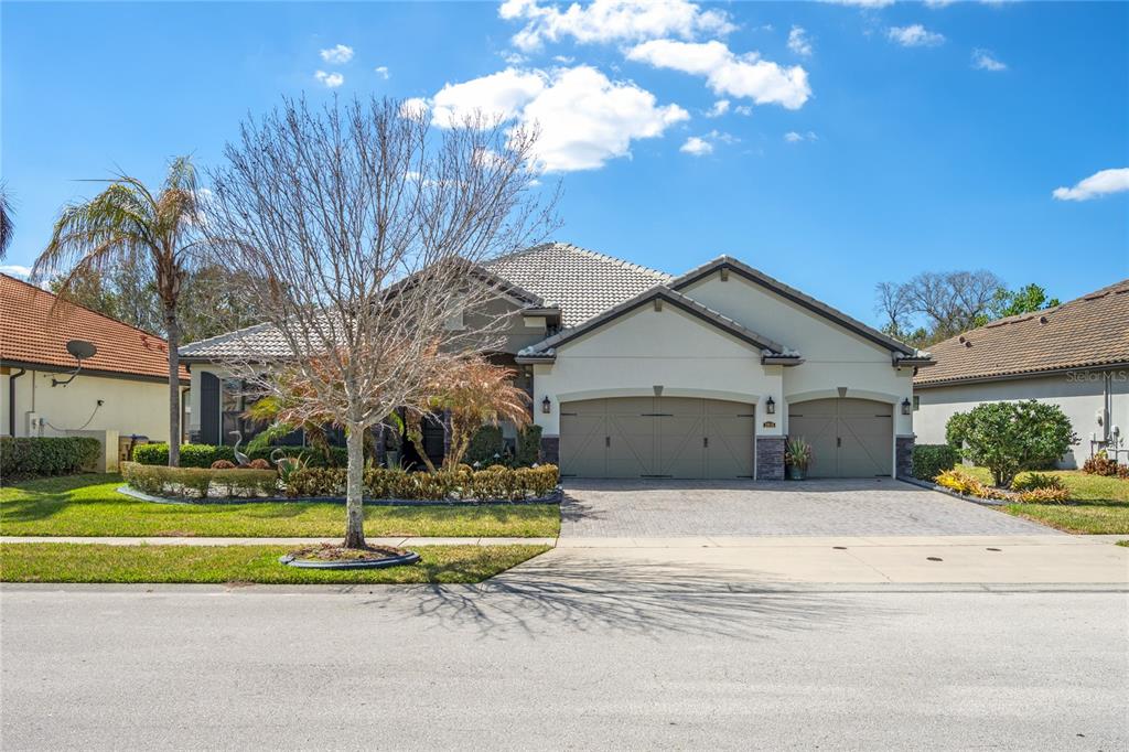 A single-story house with a three-car garage, a paved driveway, and a landscaped front yard — 3816 BOWFIN TRAIL, KISSIMMEE, FL
