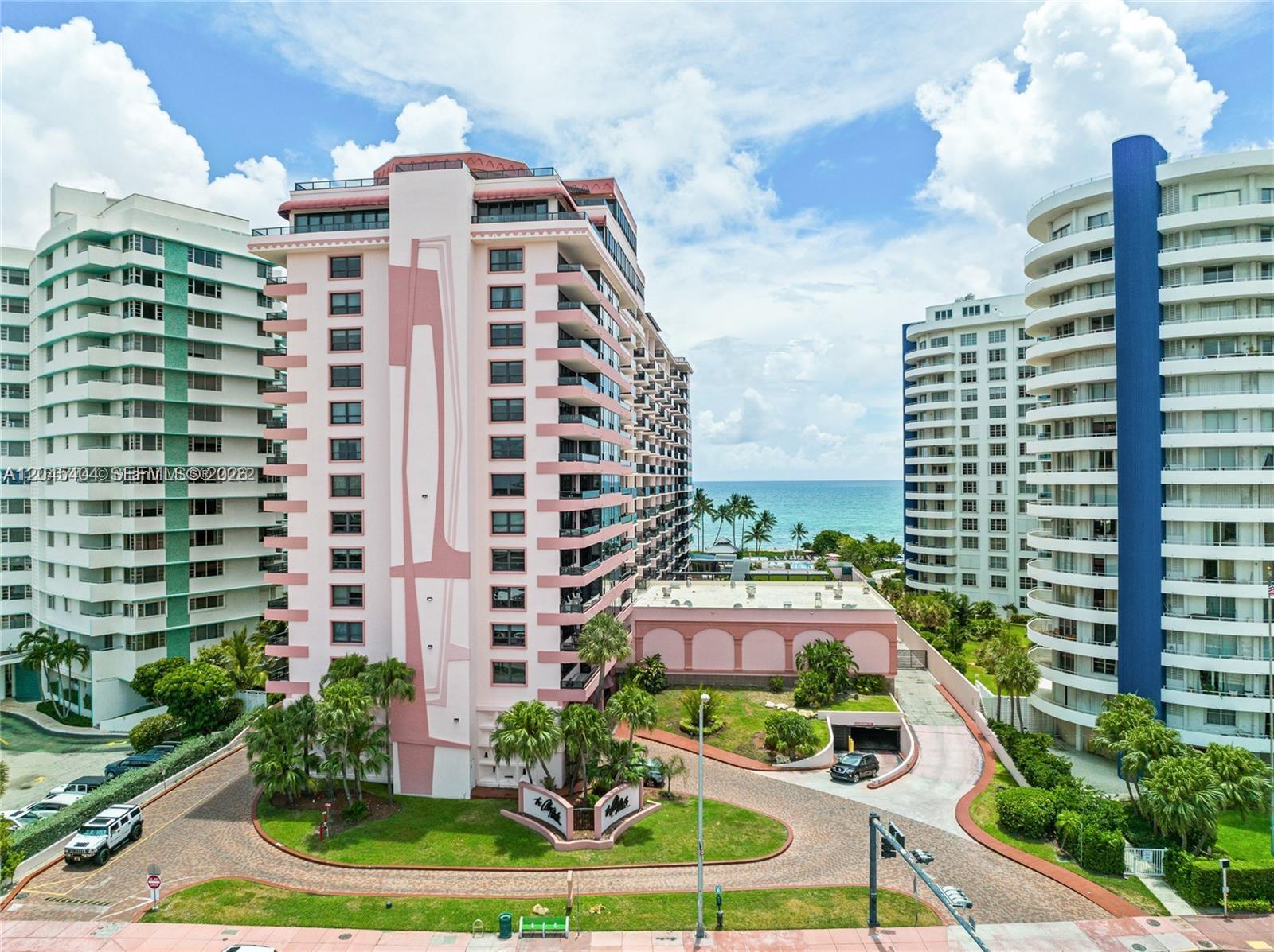 An aerial view shows a pink high-rise condominium building situated between two other apartment towers — 5225 Collins Ave # 1117, Miami Beach FL 33140, MIAMI BEACH, FL