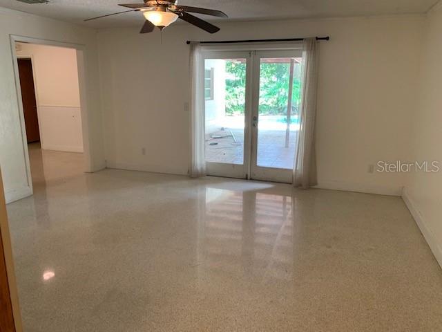 A room with light-colored terrazzo flooring, a ceiling fan, and glass doors leading outside — 6367 KEARCE STREET, ORLANDO, FL