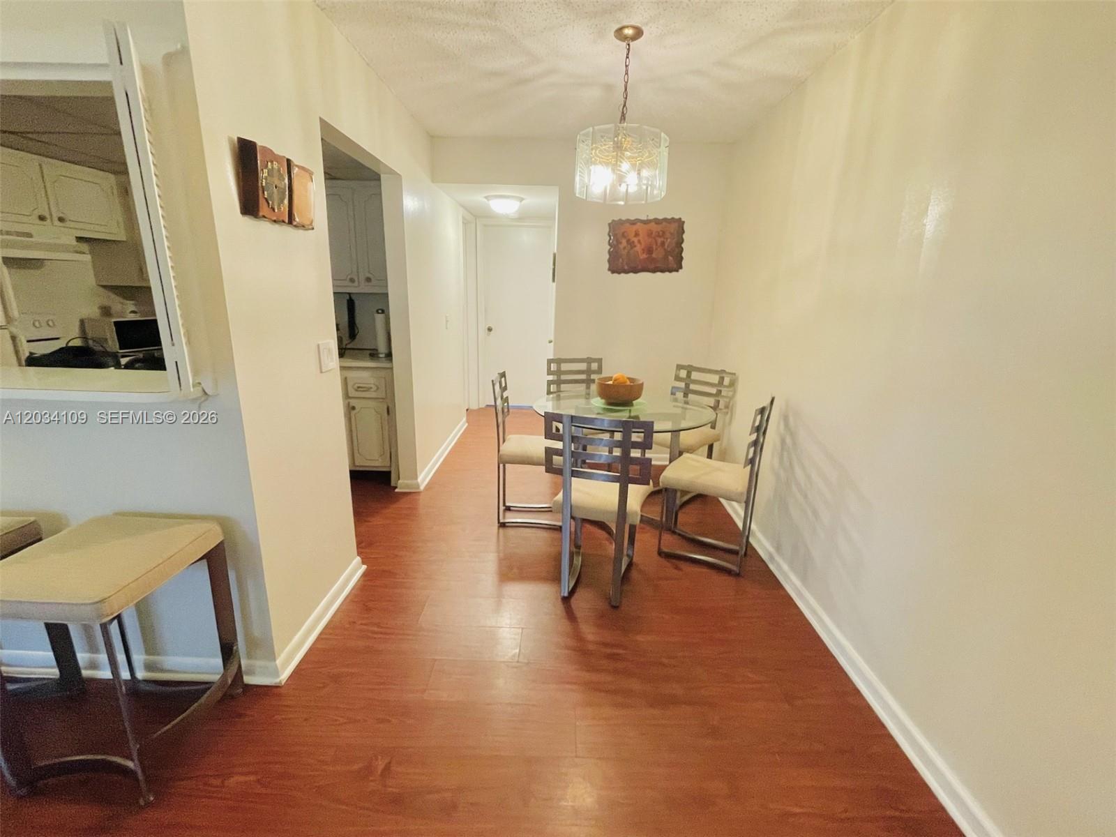 A dining area features a glass-topped table, four chairs, and wood-look flooring — 236 Durham F # 236, Deerfield Beach FL 33442, DEERFIELD BEACH, FL