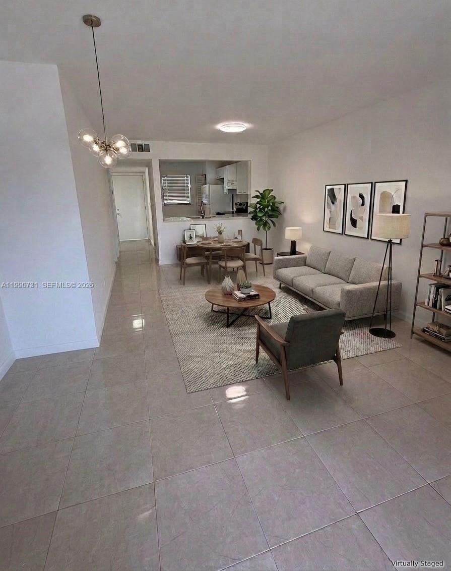 This living and dining area features tile flooring, a neutral color palette, and modern furniture — 860 NE 207th Ter # 106, Miami FL 33179, MIAMI, FL