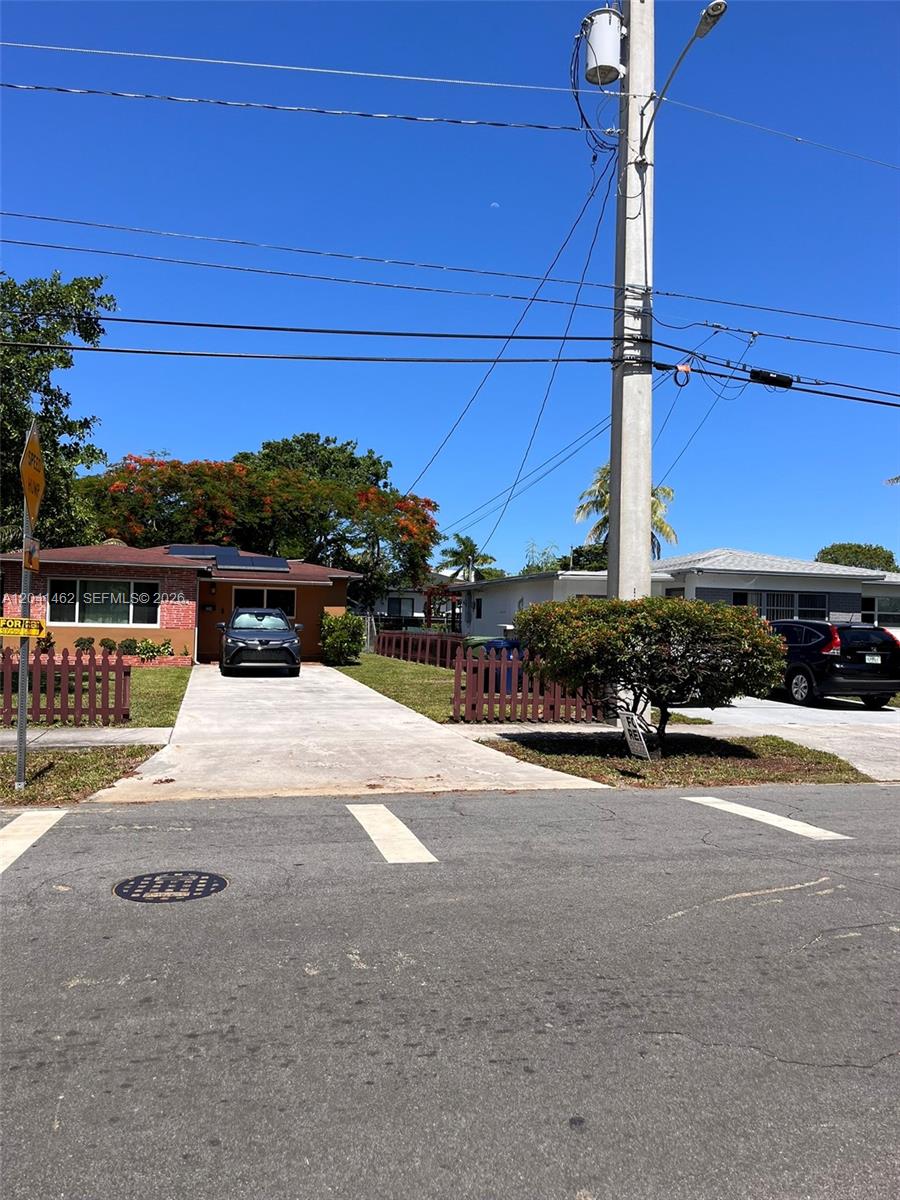 A view of two single-story houses with driveways and front yards from a paved street — 124 NW 6th Ave, Hallandale Beach FL 33009, HALLANDALE BEACH, FL