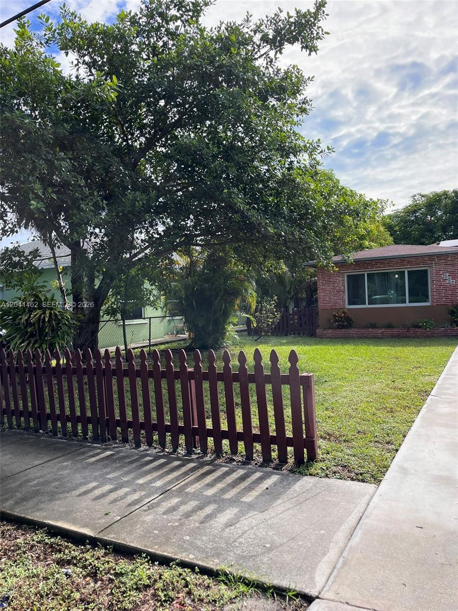 A red brick house with a front lawn and a wooden picket fence — 124 NW 6th Ave, Hallandale Beach FL 33009, HALLANDALE BEACH, FL