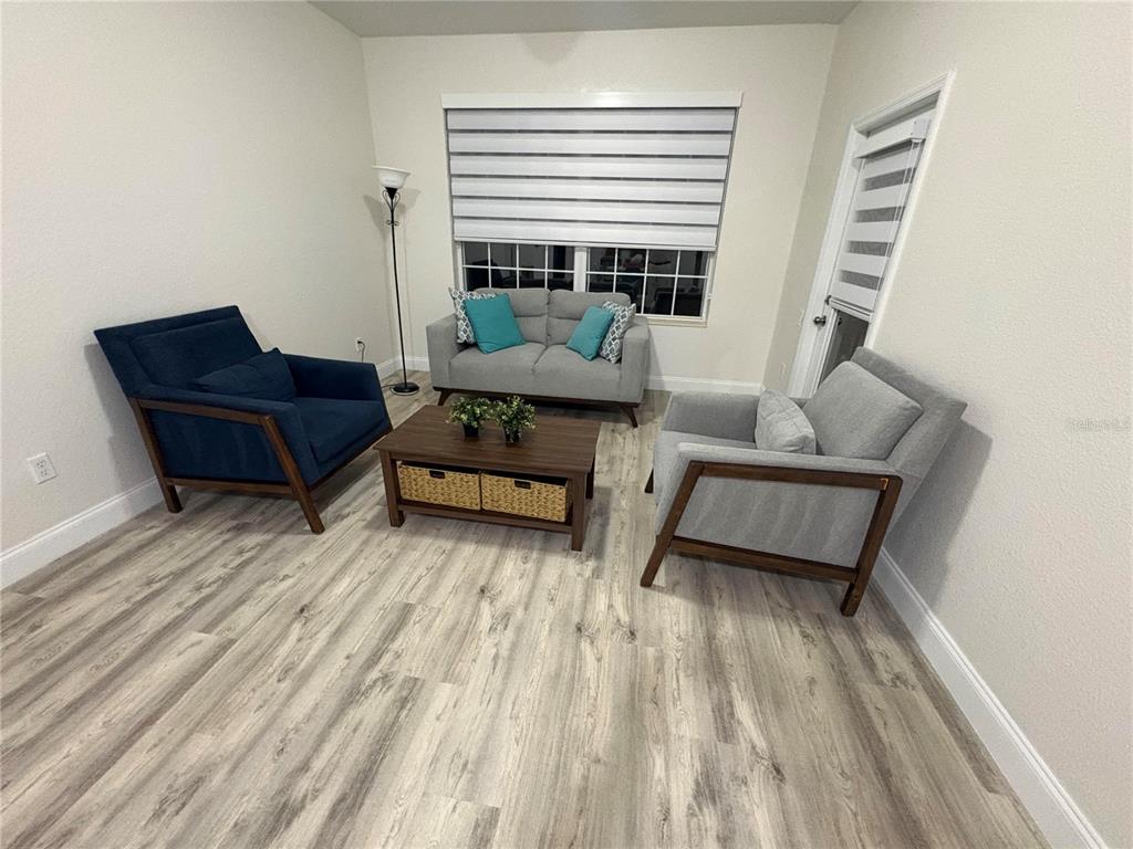 A living room features a blue armchair, a gray loveseat, and a gray armchair — 3314 ROBERT TRENT JONES DRIVE UNIT 20501, ORLANDO, FL