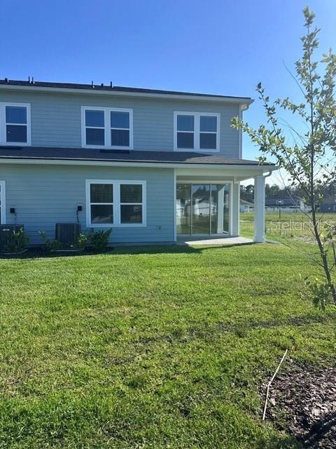 The exterior of a two-story light blue house with a covered patio and grass yard — 127 CAMPHOR LAUREL ROAD, ST AUGUSTINE, FL