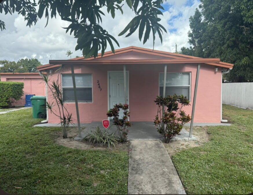 A single-story pink house with a front porch, metal roof, and a concrete walkway — 2467 NW 90th Street, Miami FL 33147, MIAMI, FL