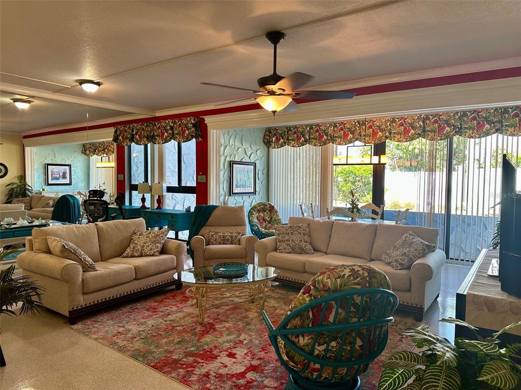 A living room features beige sofas, a patterned area rug, and a ceiling fan — 500 PARK BOULEVARD S UNIT 46, VENICE, FL