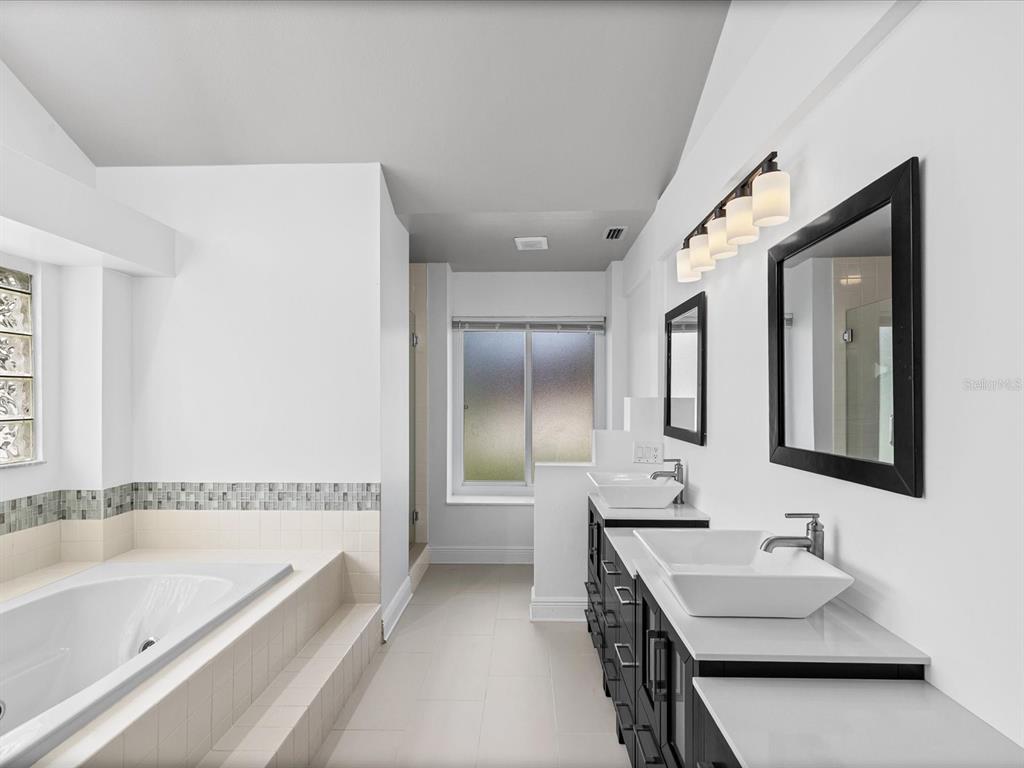 A bathroom features a soaking tub, double vanity with vessel sinks, and a walk-in shower — 1302 HENRY AVENUE, SPRING HILL, FL
