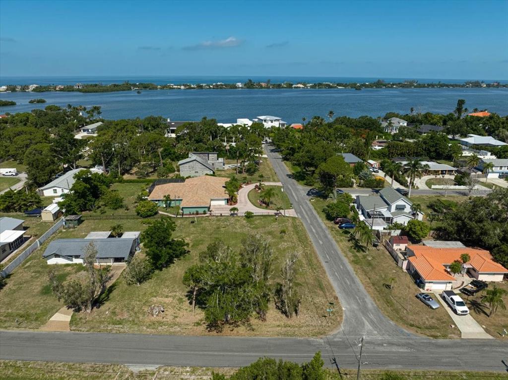 An aerial view shows a residential street leading toward a large body of water — SARABAY ROAD, OSPREY, FL