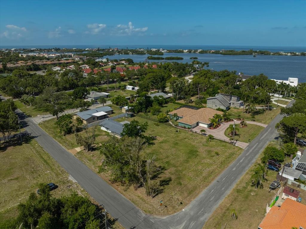 An aerial view shows a large residential lot with a house near a coastal bay — SARABAY ROAD, OSPREY, FL