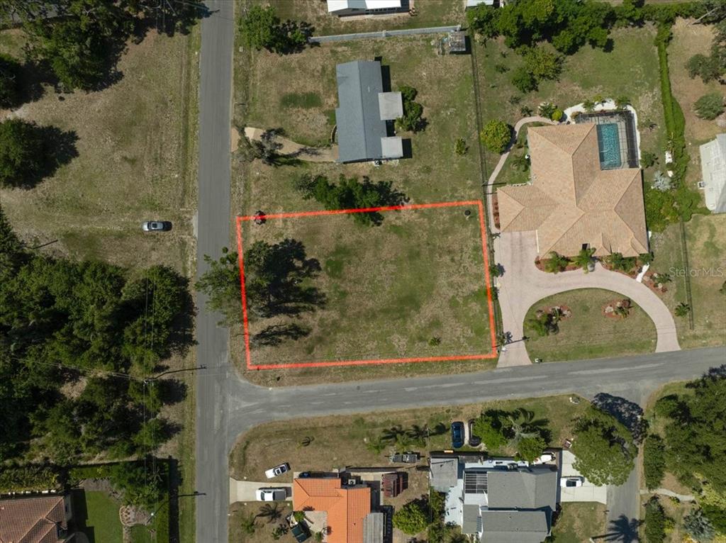 An aerial view shows a vacant rectangular lot outlined in red next to a house — SARABAY ROAD, OSPREY, FL