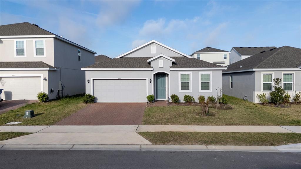 A single-story gray house with a two-car garage and a front-facing entrance — 1867 LAKE INDIGO ROAD, GROVELAND, FL