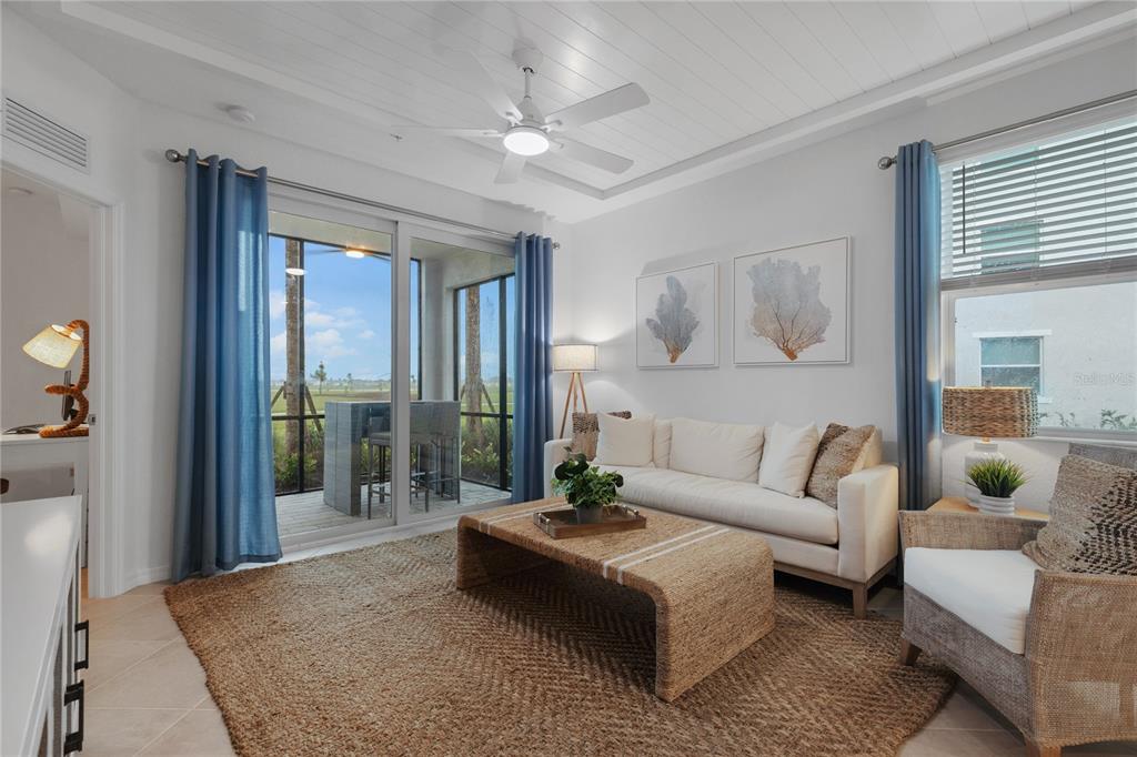 A living room features a white sofa, woven coffee table, and sliding doors to a patio — 17630 OPAL SAND DRIVE UNIT 108, VENICE, FL