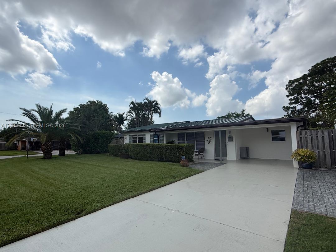 A single-story house with a white exterior, a metal roof, and a paved driveway — 330 NE 48th St, Oakland Park FL 33334, OAKLAND PARK, FL