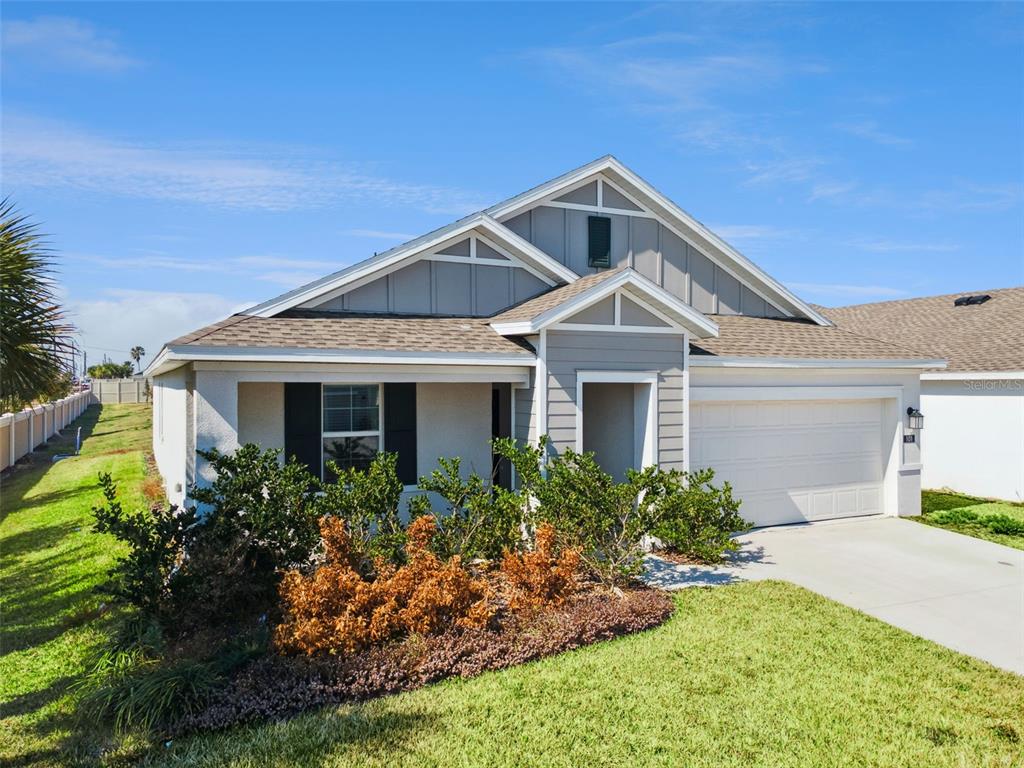 A single-story house with gray siding, a two-car garage, and a landscaped front yard — 101 KAYAK AVENUE, HAINES CITY, FL