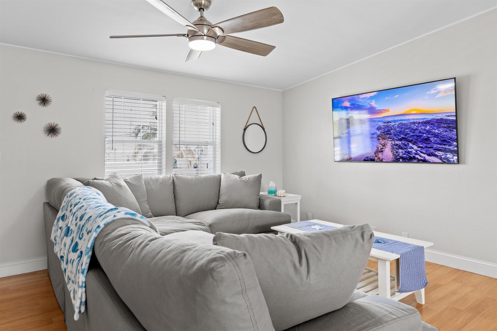 A living room features a gray sectional sofa, a ceiling fan, and a wall-mounted television — 915 80th Street, Marathon FL 33050, MARATHON, FL