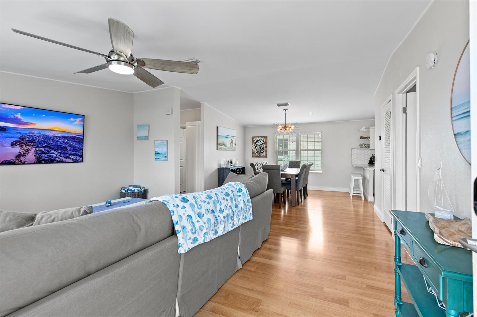 A living room and dining area feature light wood flooring, a ceiling fan, and furniture — 915 80th Street, Marathon FL 33050, MARATHON, FL