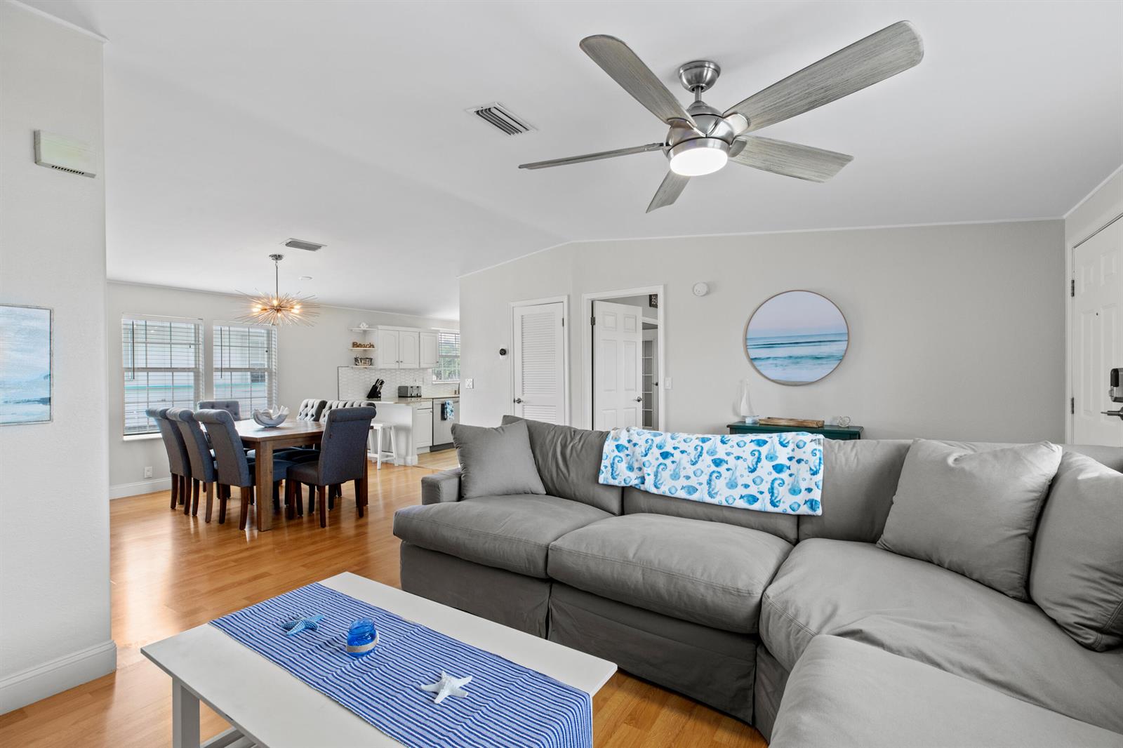A living room with a gray sectional sofa, ceiling fan, and an adjacent dining area — 915 80th Street, Marathon FL 33050, MARATHON, FL