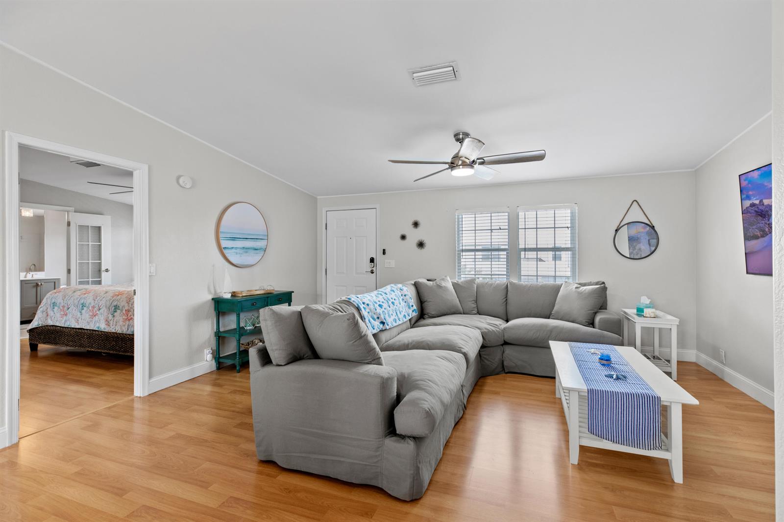 A living room features a gray sectional sofa, a white coffee table, and wood flooring — 915 80th Street, Marathon FL 33050, MARATHON, FL