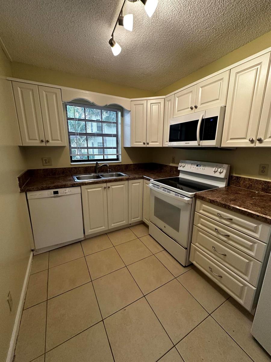 An empty room with light-colored walls, wood-look flooring, a ceiling fan, and a sliding glass door — 321 Olivewood Place # 121, Boca Raton FL 33431, BOCA RATON, FL