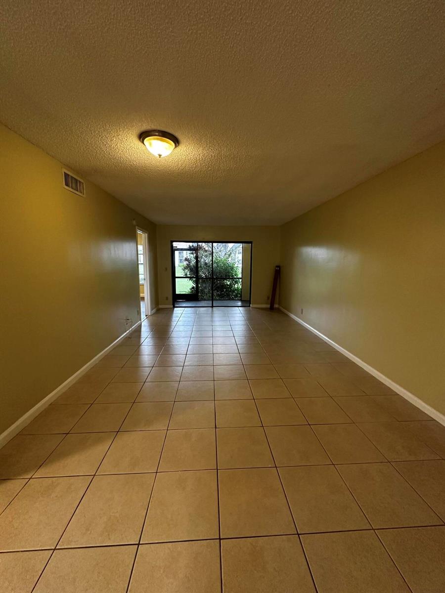 An empty bedroom features light-colored walls, a ceiling fan, and wood-look flooring — 321 Olivewood Place # 121, Boca Raton FL 33431, BOCA RATON, FL
